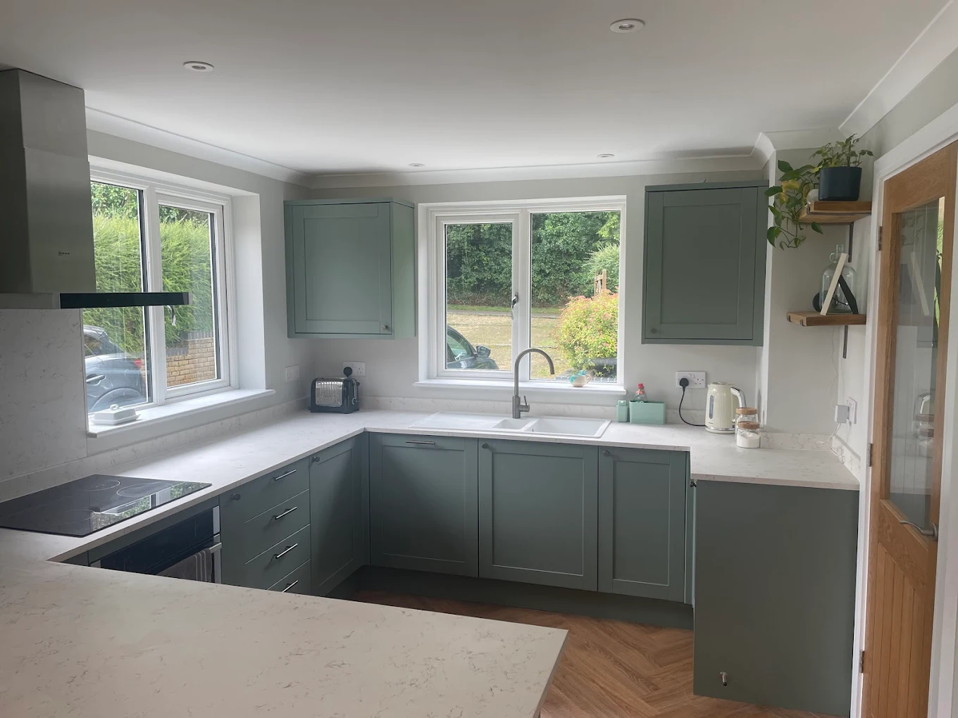 Sage-green shaker fitted kitchen with quartz worktops by D.K. Carpentry